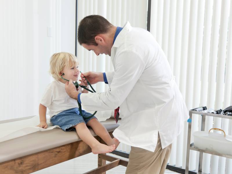 Médico examinando criança para diagnóstico precoce de Pectus